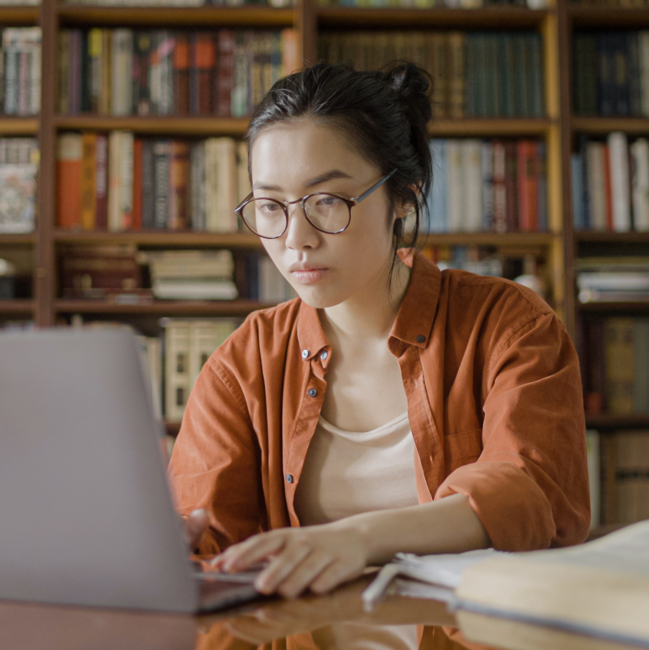 Female student studying at a desk with a laptop.
