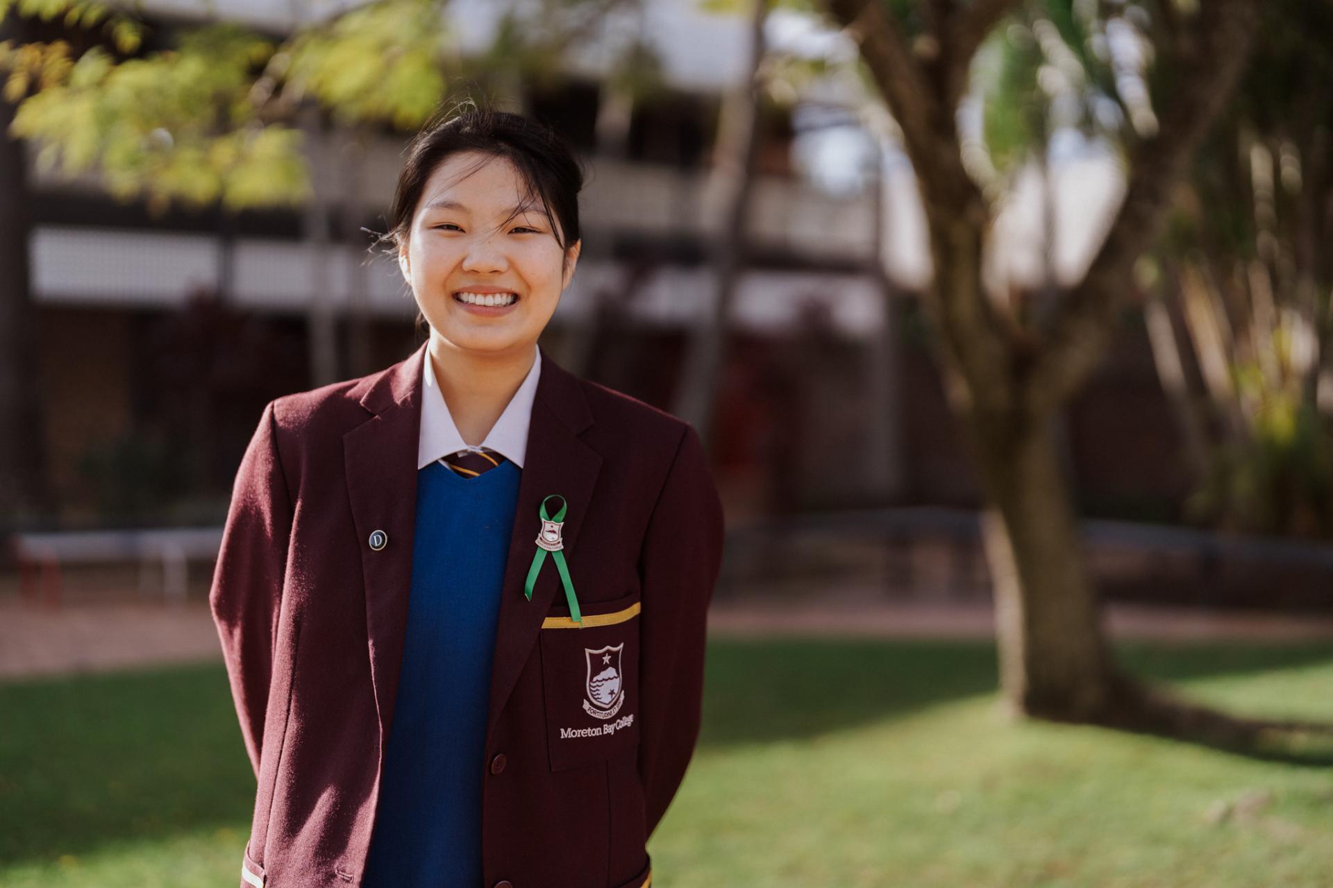 Female high school student smiling at the camera.