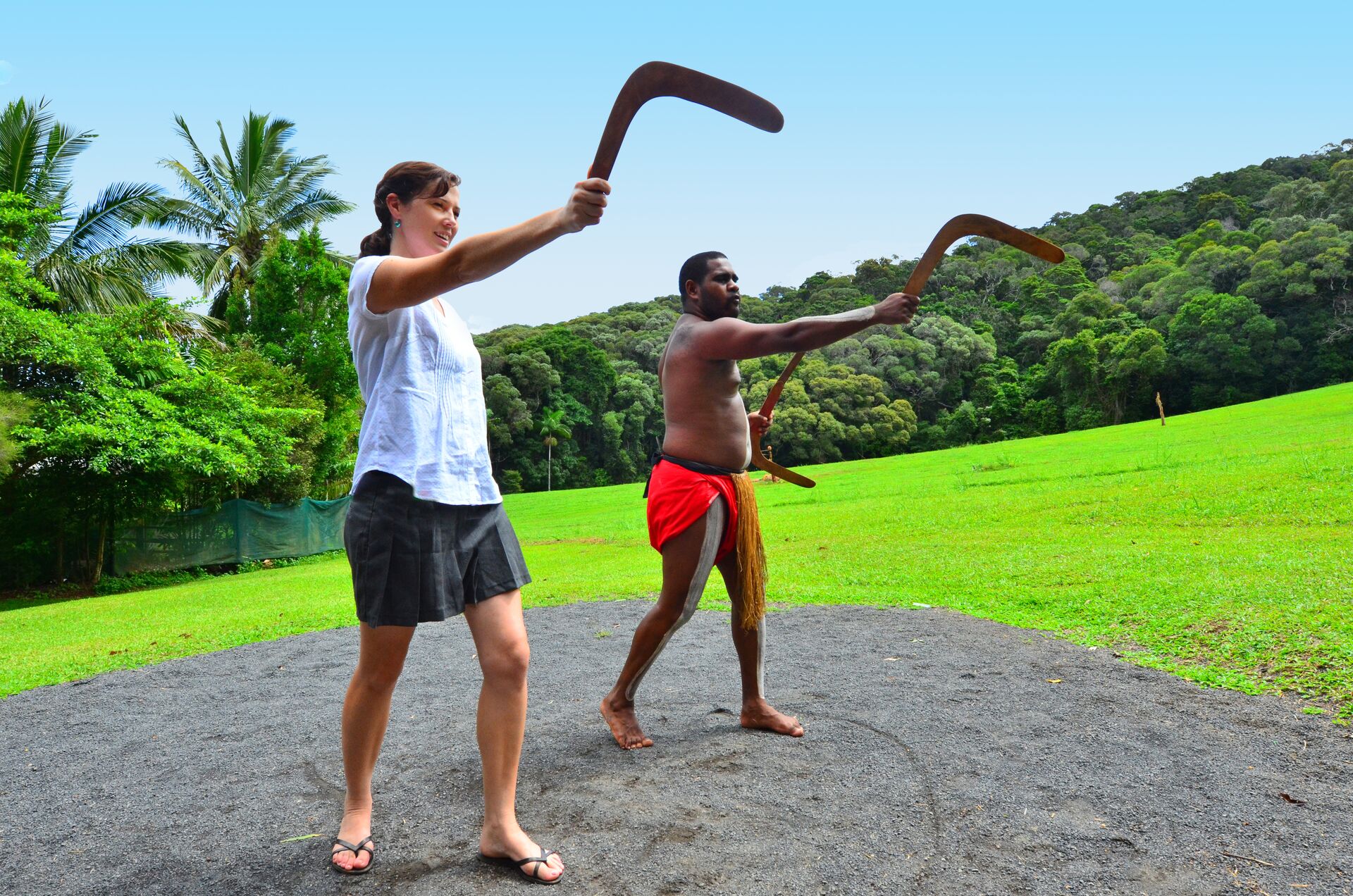 Indigenous man demonstrating boomerang throwing to a tourist in Queensland.